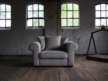 Country armchair / loveseat in a gray beige fabric with back cushions.