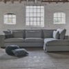 Corner sofa Annabelle with an ottoman element in a gray fabric and with lumbar cushions