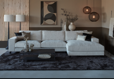 Corner sofa Joëlle in a light sand-colored fabric with a large rug