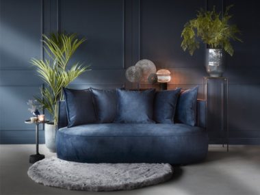 2-Sitzer-Sofa Adèle mit passenden Zierkissen aus blauem Samt mit rundem Teppich