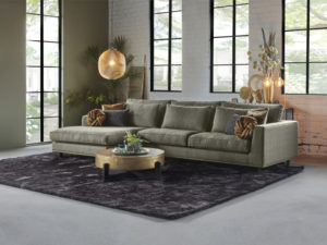 Corner sofa in a boucle fabric, color thyme green. With gold round coffee table.