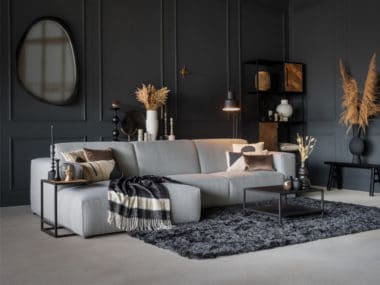 Corner sofa in a light gray fabric, with a rectangular rug