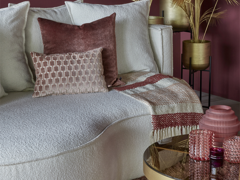 Lounge Sofa Adèle Curve, ein Sofa mit runden Formen und ein runder Teppich. rosa und goldene Dekoration.