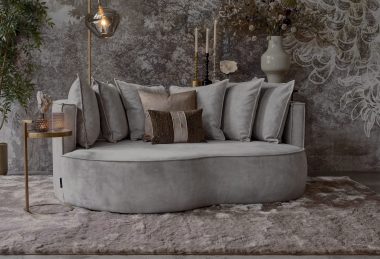 Loungebank met organische vormen en bijpassende rugkussens in een grijze velvet stof