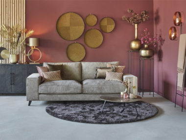3místná pohovka Joëlle v barvě taupe s kulatým koberečkem a odpovídajícími dekorativními polštáři