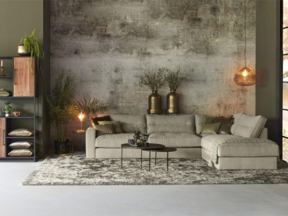 Corner sofa in a gray / beige colored fabric with a generous rug