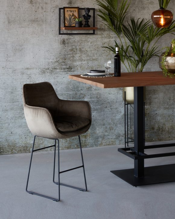 Velvet gray bar stool Max 66 cm at a wooden bar table