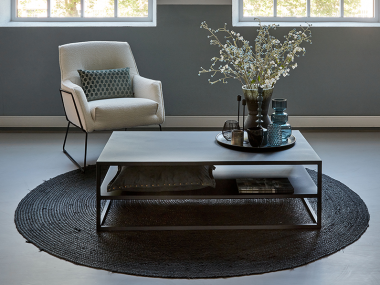 Black Heavy Metal Coffeetable 120cm, with boucle armchair and round rug.