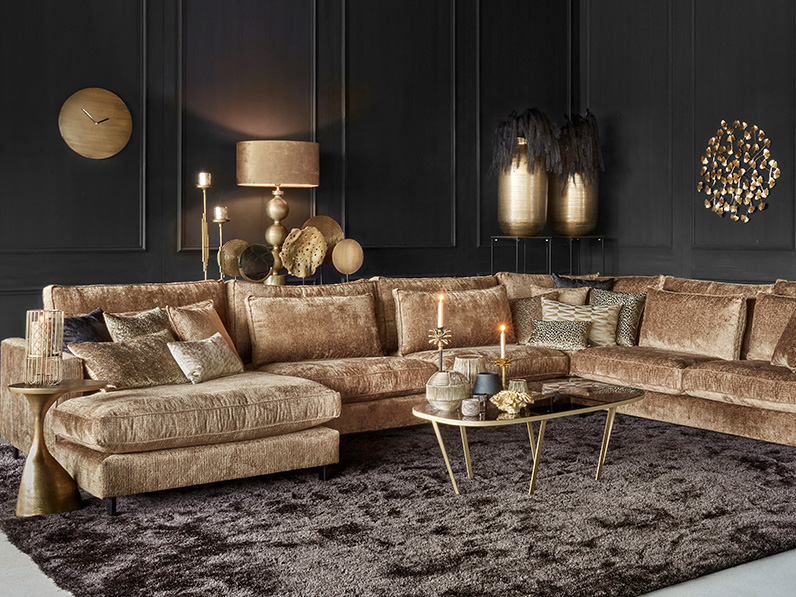Gold sofa with dark accessories and walls