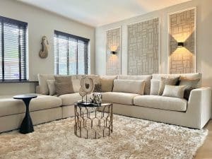 Blick ins schicke Interieur: Beiges Sofa mit Kissen und goldenen Details