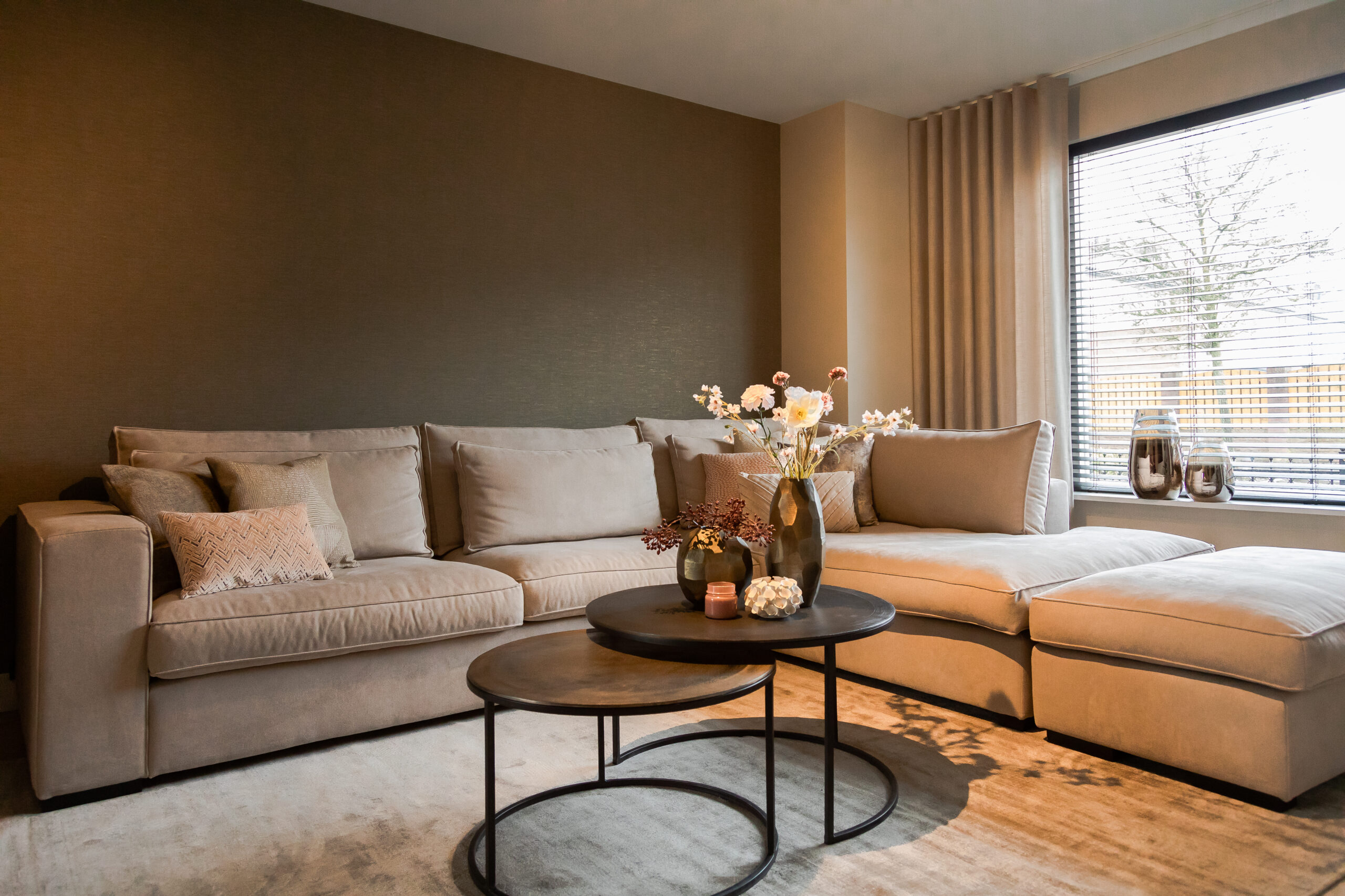 Canapé d'angle beige avec coussins confortables et ensemble table basse ronde