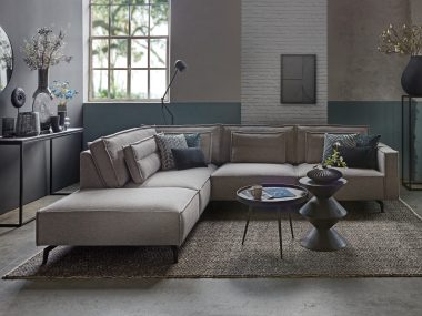 Gray Christiane corner sofa with upright stitching. Styled with black decoration.
