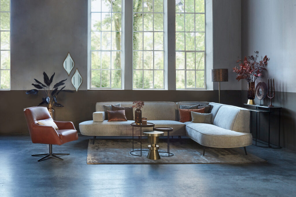 أريكة زاوية باللون البيج Arielle ذات أشكال مستديرة وكرسي بذراعين من جلد الكونياك Tommy Narrow.