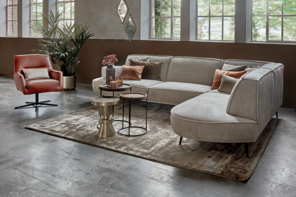 Beige corner sofa Arielle with round shapes and cognac leather armchair Tommy Smal.