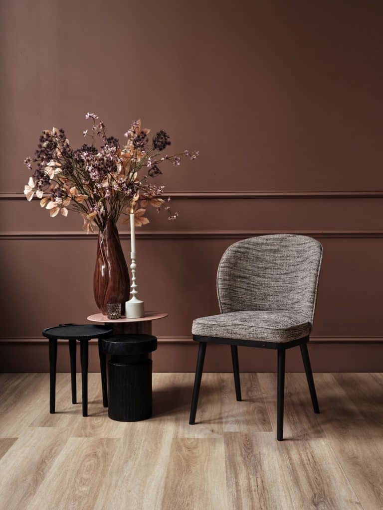 Chaise de salle à manger dans un tissu luxueux avec une teinte rouge-rose.