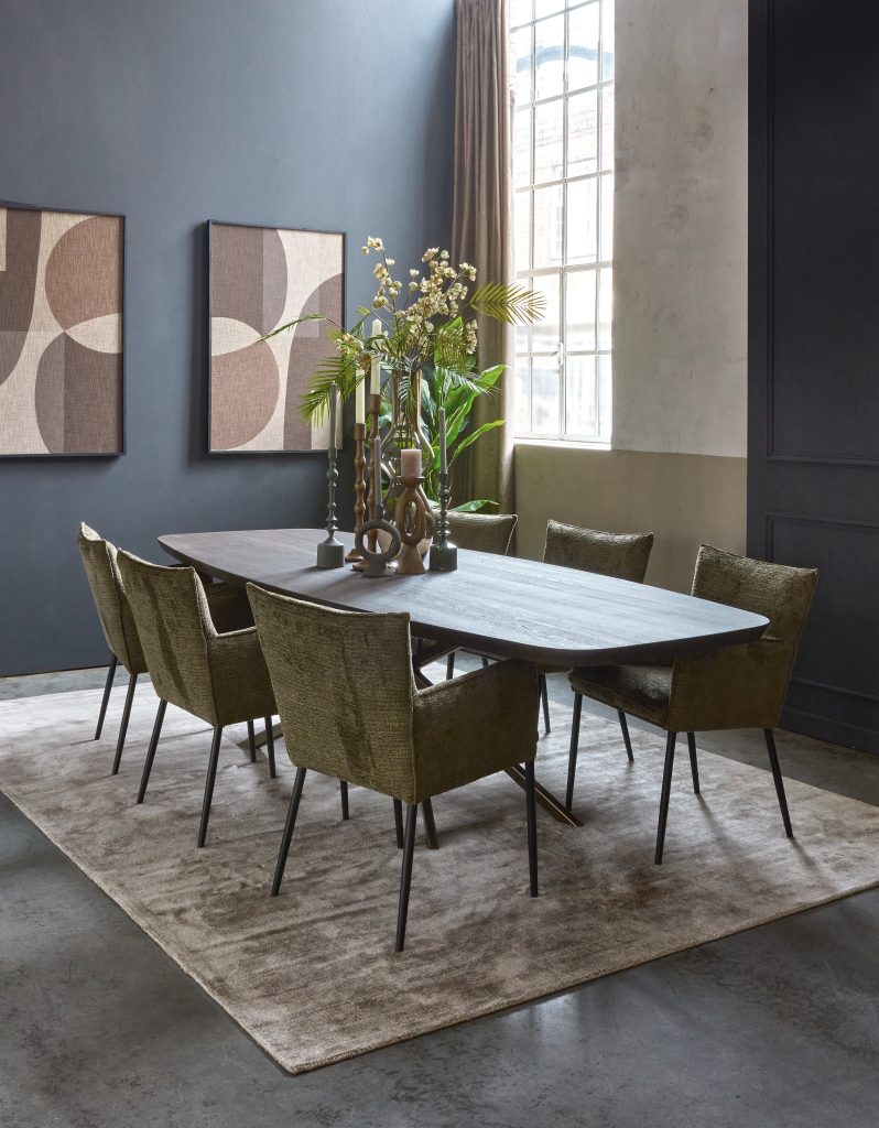 Danish oval dining table in a dark brown color. Solid wood. With moss green dining room chairs with armrests. Atmospheric styling.