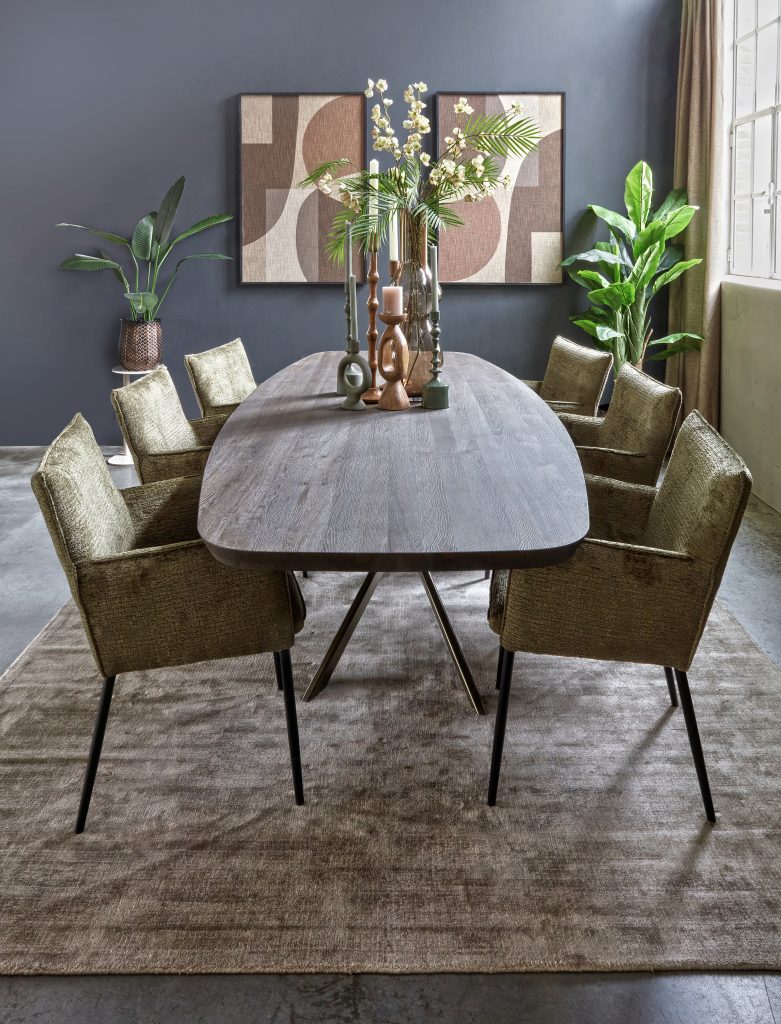 Danish oval dining table in a dark brown color. Solid wood. With moss green dining room chairs with armrests. Atmospheric styling.