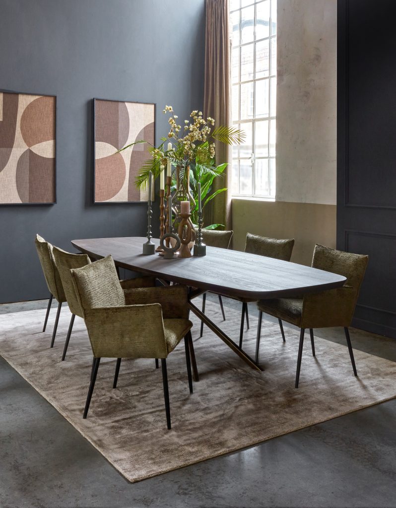 Dánský oválný jídelní stůl v tmavě hnědé barvě. Masivní dřevo. S mechově zelenými jídelními židlemi s područkami. Atmosférický styl.