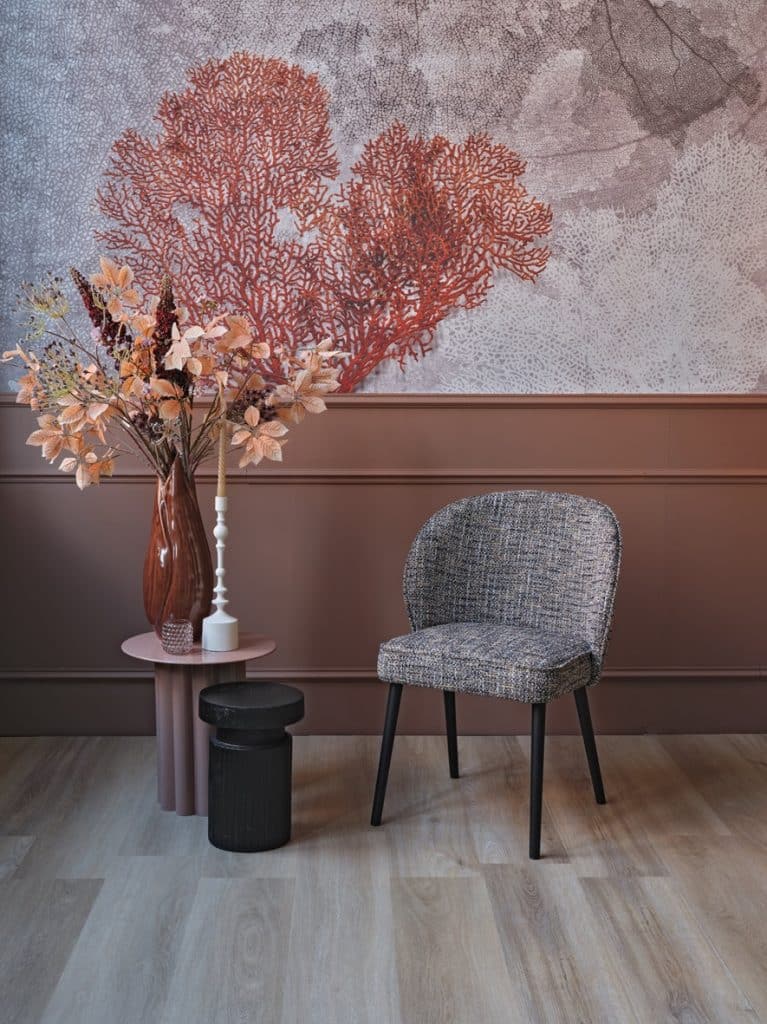 Chaise de salle à manger dans un luxueux tissu rose. Avec des pattes noires.