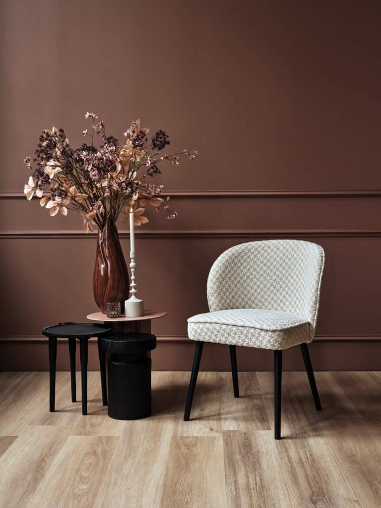 Chaise de salle à manger dans un luxueux tissu rose. Avec des pattes noires.