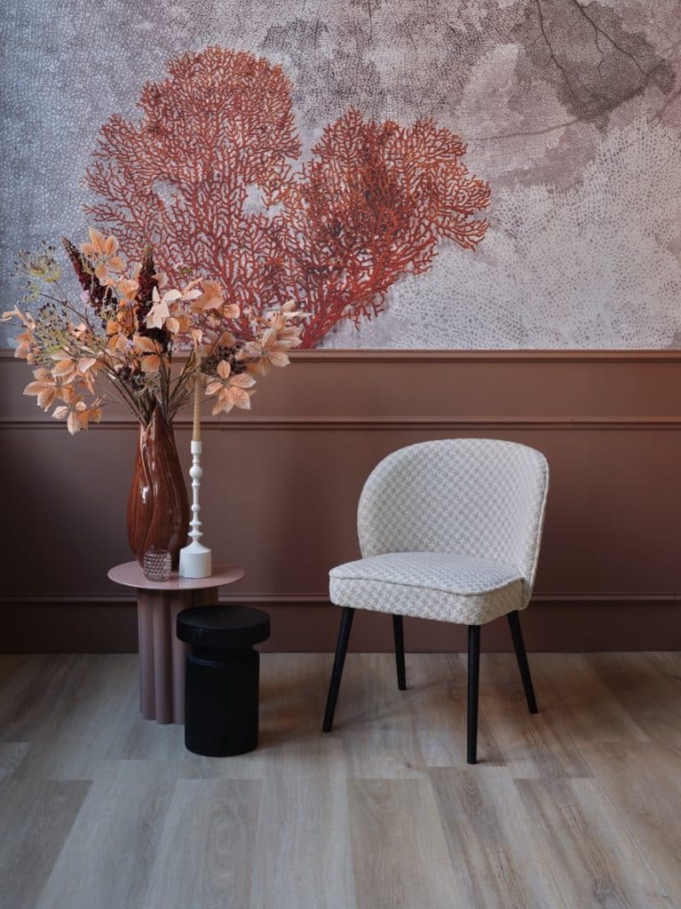 Chaise de salle à manger dans un luxueux tissu rose. Avec des pattes noires.