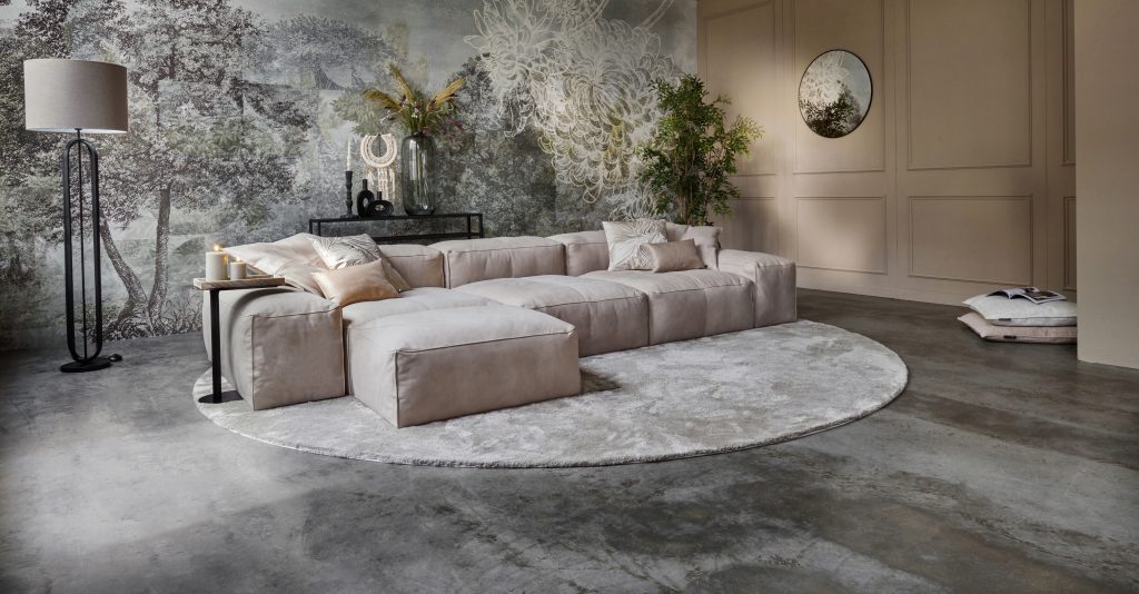 Foto con vista obliqua del divano componibile grigio con pouf
