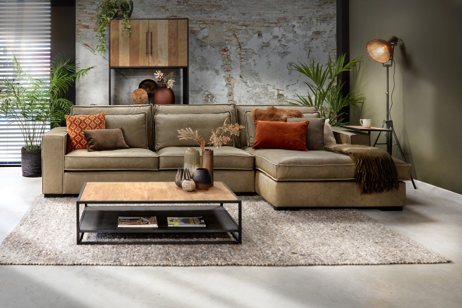 أريكة خضراء من Room108 بتصميم داخلي رائع مع وسائد زخرفية برتقالية