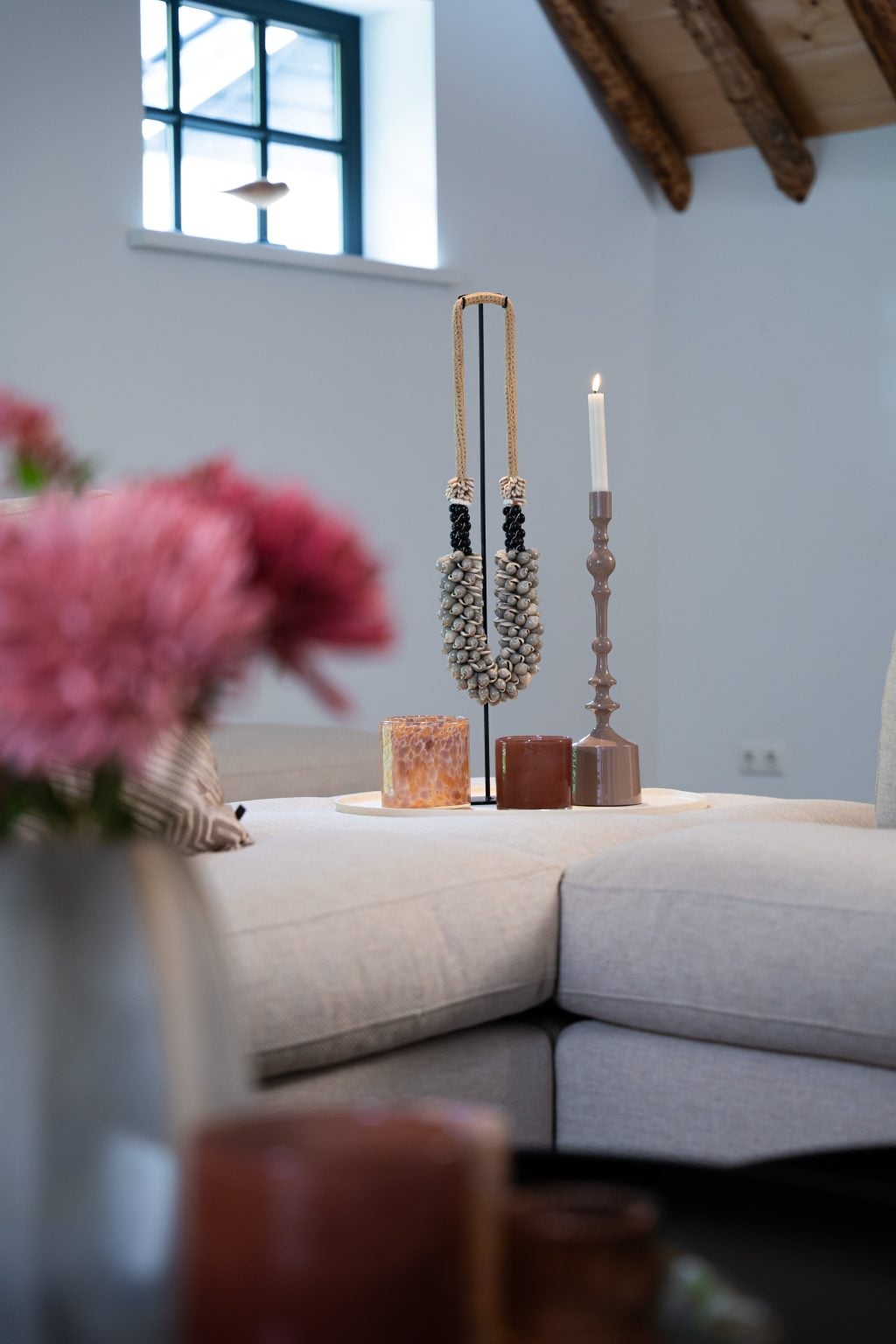 Grand canapé d'angle en forme de U avec un tapis sombre et des accessoires chics.