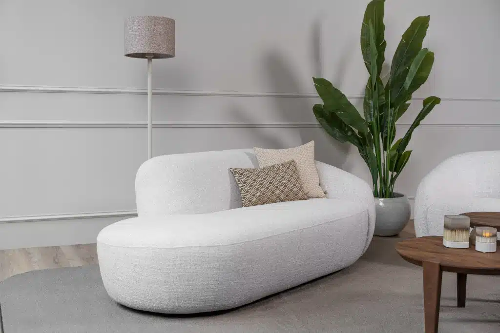 Deze royale loungestoel zit tussen een fauteuil en een loveseat in. Met een schuin geplaatste rugleuning en in een lichtgrijze kleur is de Lenny Lazy een statementpiece.