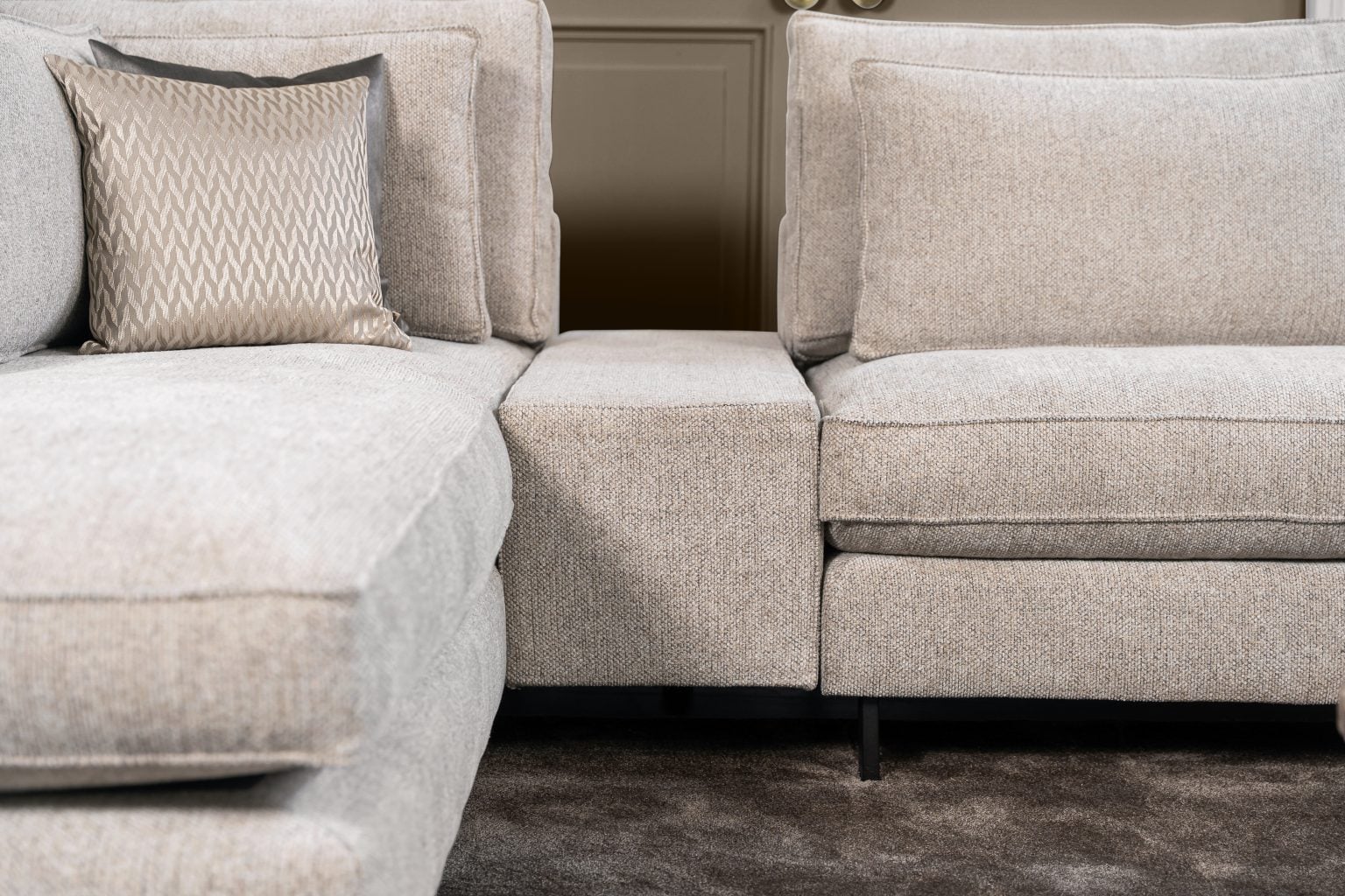 Ecksofa Gigi in einem neutralen Beigeton, mit Accessoires in warmen Erdtönen gestylt.