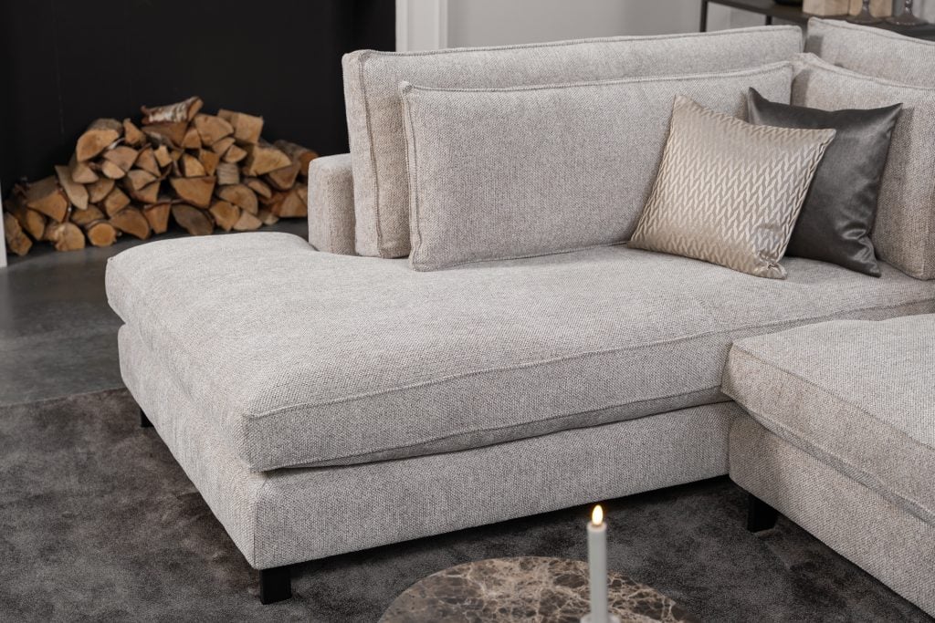 Hoekbank Gigi in een neutrale beige kleur, gestyled met accessoires in warme aardetinten.