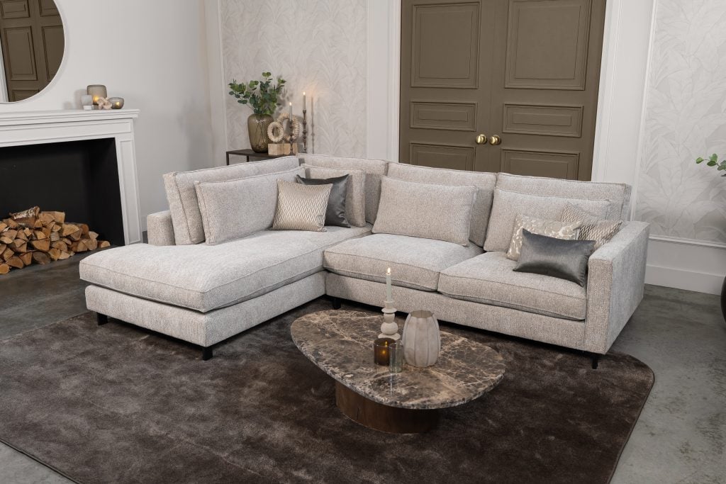 Hoekbank Gigi in een neutrale beige kleur, gestyled met accessoires in warme aardetinten.