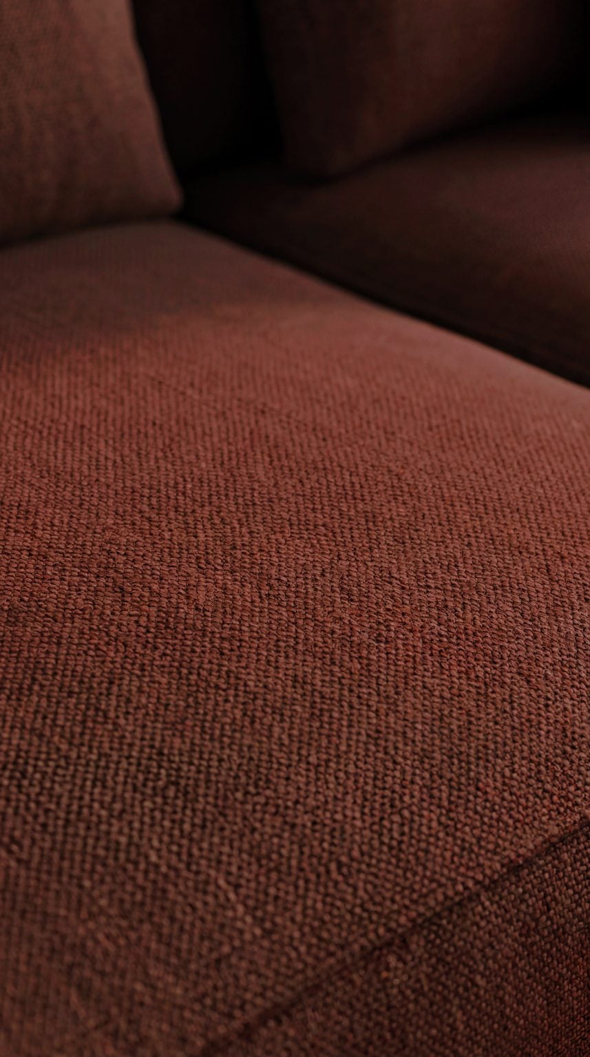 Room108 Annabelle hoekbank met longchair en ottomane in stof Crisp Burgundy 034 in een warm en sfeervol interieur.
